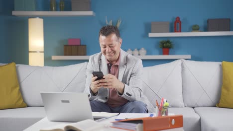 Man-working-from-home-enjoys-mobile-apps-on-phone.